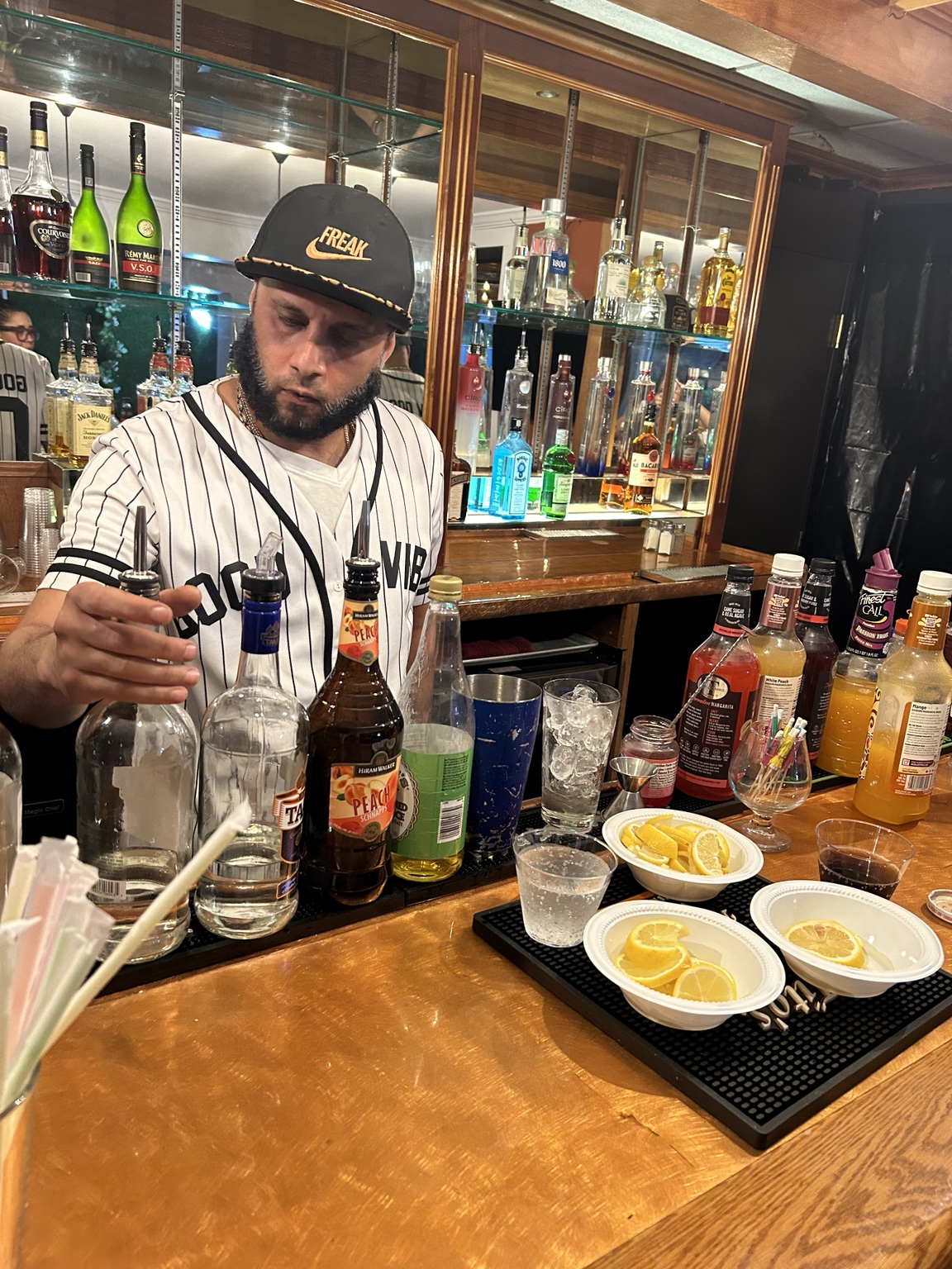 Bartender practicing cocktail preparation with tools and ingredients