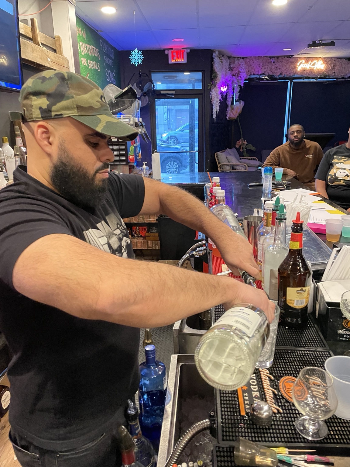 Bartender practicing a measured pour at the bar