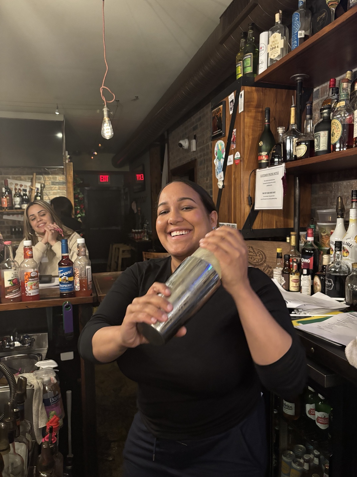 Student smiling while practicing cocktail shaking technique